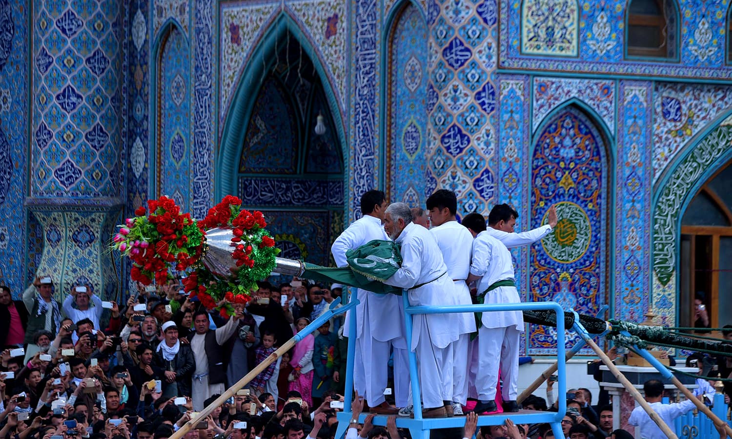 Afghan devotees cheer as they lift a holy mace in front of The Sakhi Shrine in Kabul. ─ AFP