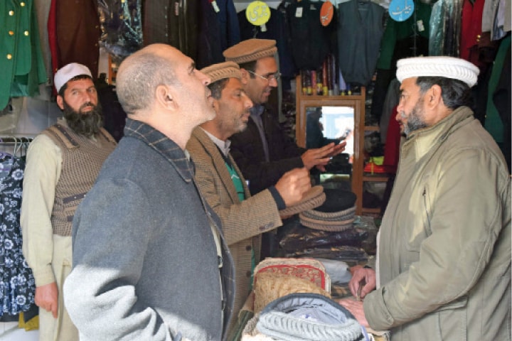 Buyers at a cap outlet in Mingora. &mdash;Dawn