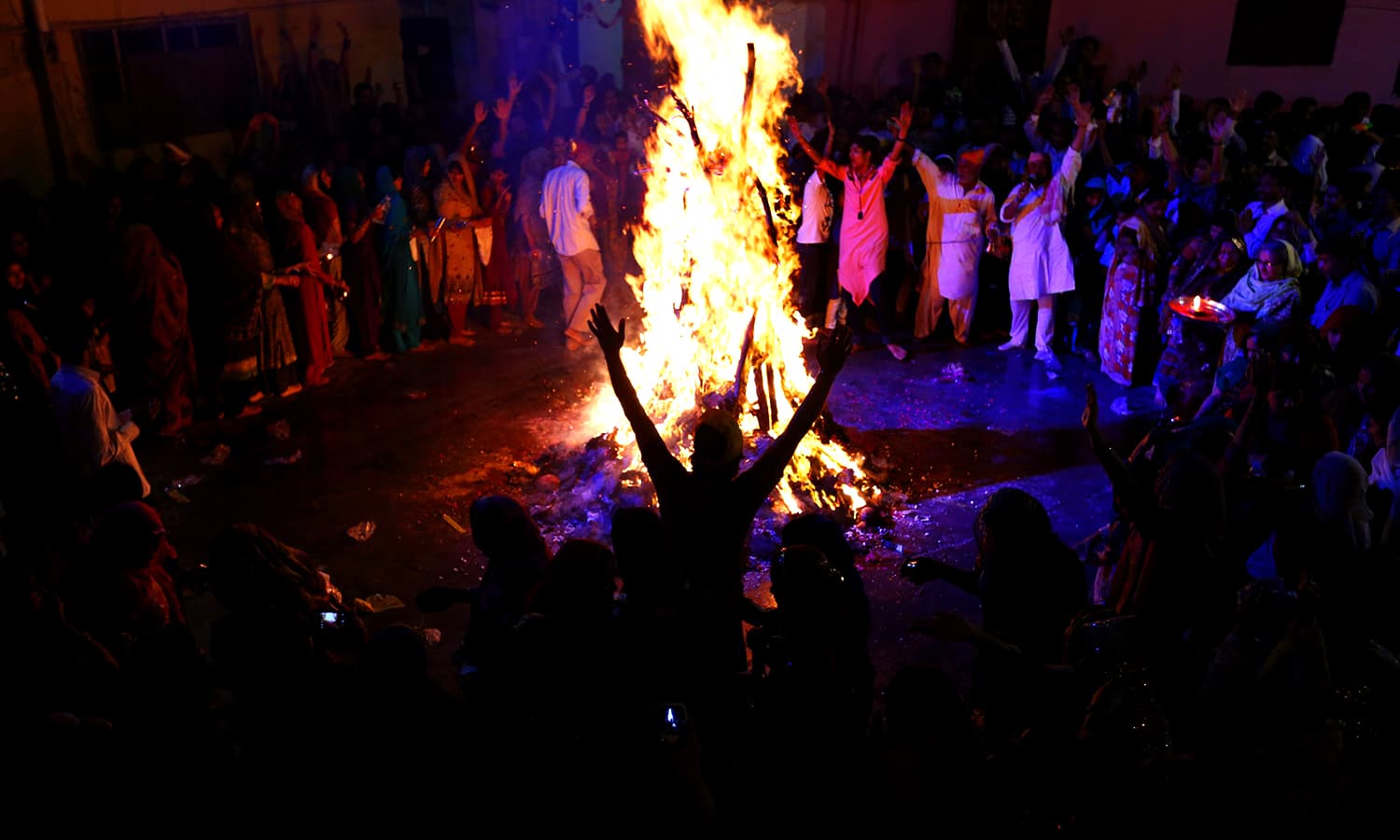 Members of the Hindu community gather around a bonfire as they take part in celebrations for Holi in Karachi. ─ Reuters