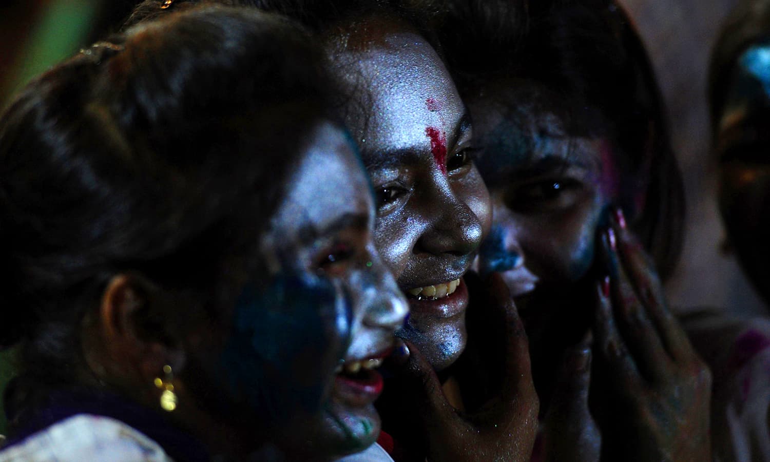 Girls look on as they participate in celebrations for the Holi festival in Karachi. — AFP