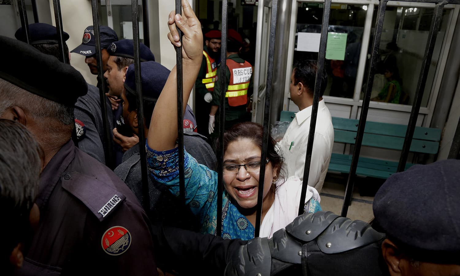 A woman weeps for her injured family members as she tries to speak to security at a local hospital in Lahore.─AP