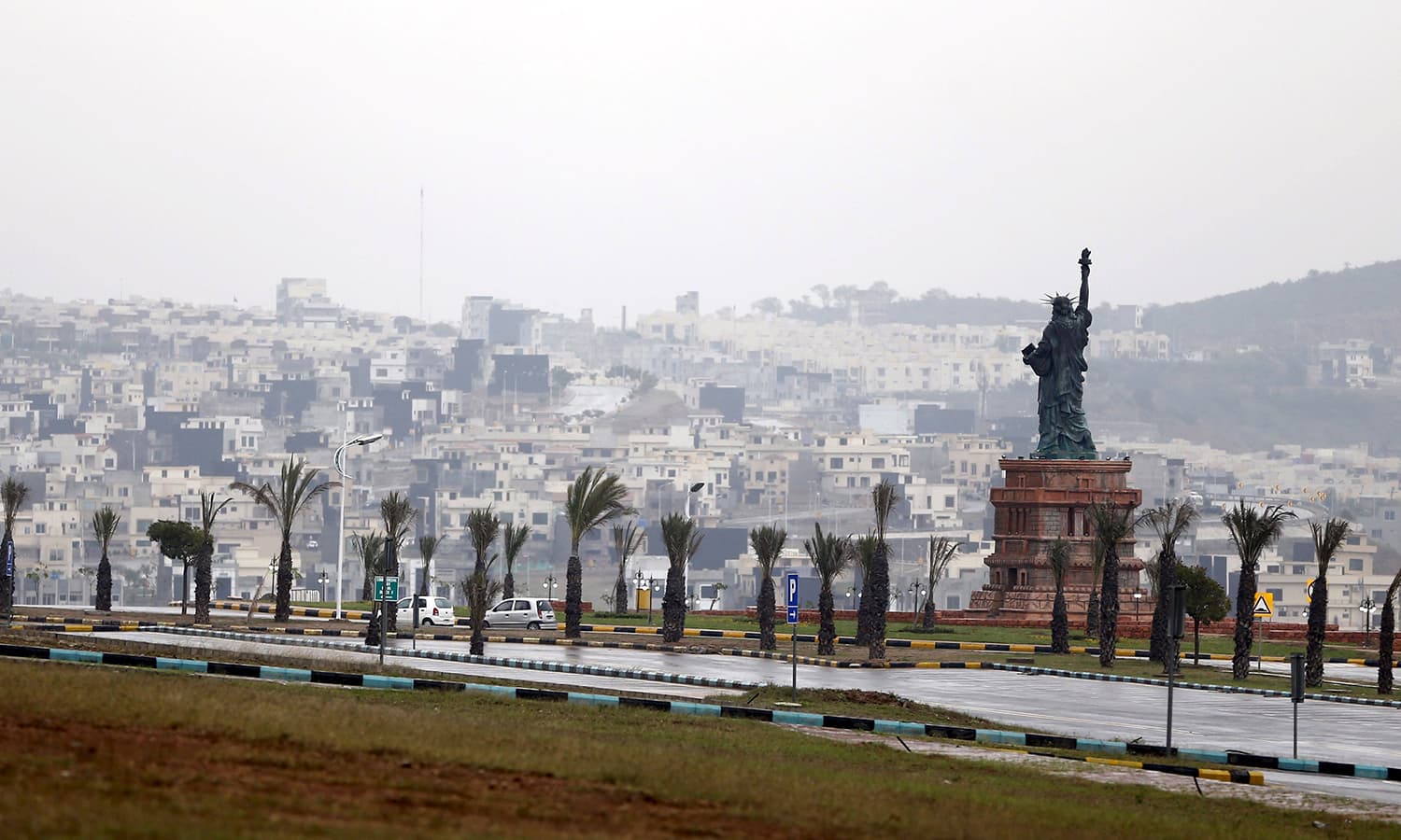 A replica of the Statue of Liberty stands on a hill overlooking the construction of new homes in Bahria Town on the outskirts of Islamabad.─Reuters