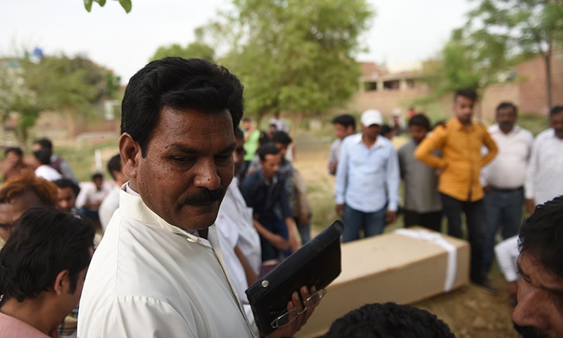 Pastor Shakeel Anjum attends the funeral of a suicide blast victim at a graveyard in Lahore.─AFP