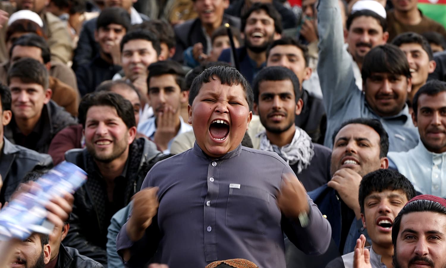 A boy goes all jubilant as crowds gather to welcome the Afghan cricket team. — AFP