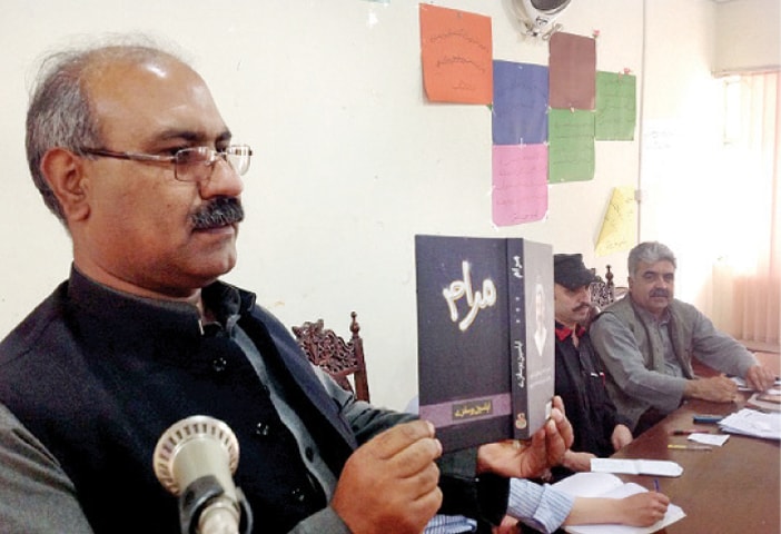 Prof Sherzaman Seemab shows the poetry collection to the participants at Pashto Academy, Peshawar, on Thursday. &mdash; Dawn