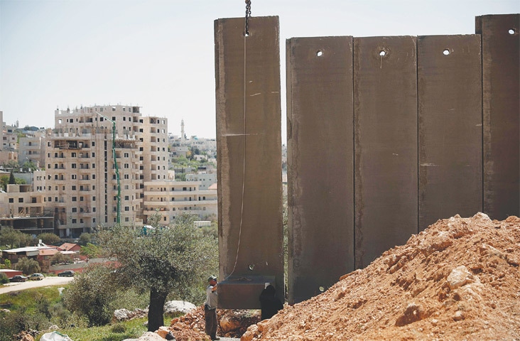 Beit Jala: Israeli workers place the new section of the separation barrier.&mdash;AFP