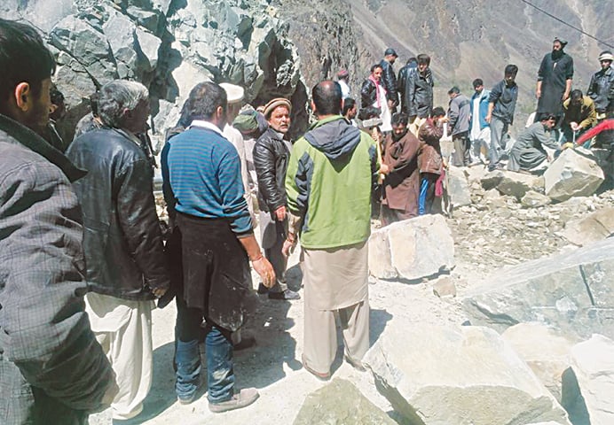 People clearing the Karakoram Highway blocked by landslides.—Dawn