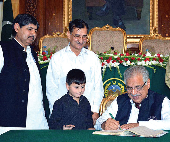 Khyber Pakhtunkhwa Governor Iqbal Zafar Jhagra signing an admission form in Peshawar on Friday while inaugurating the Fata enrolment campaign. &mdash;APP