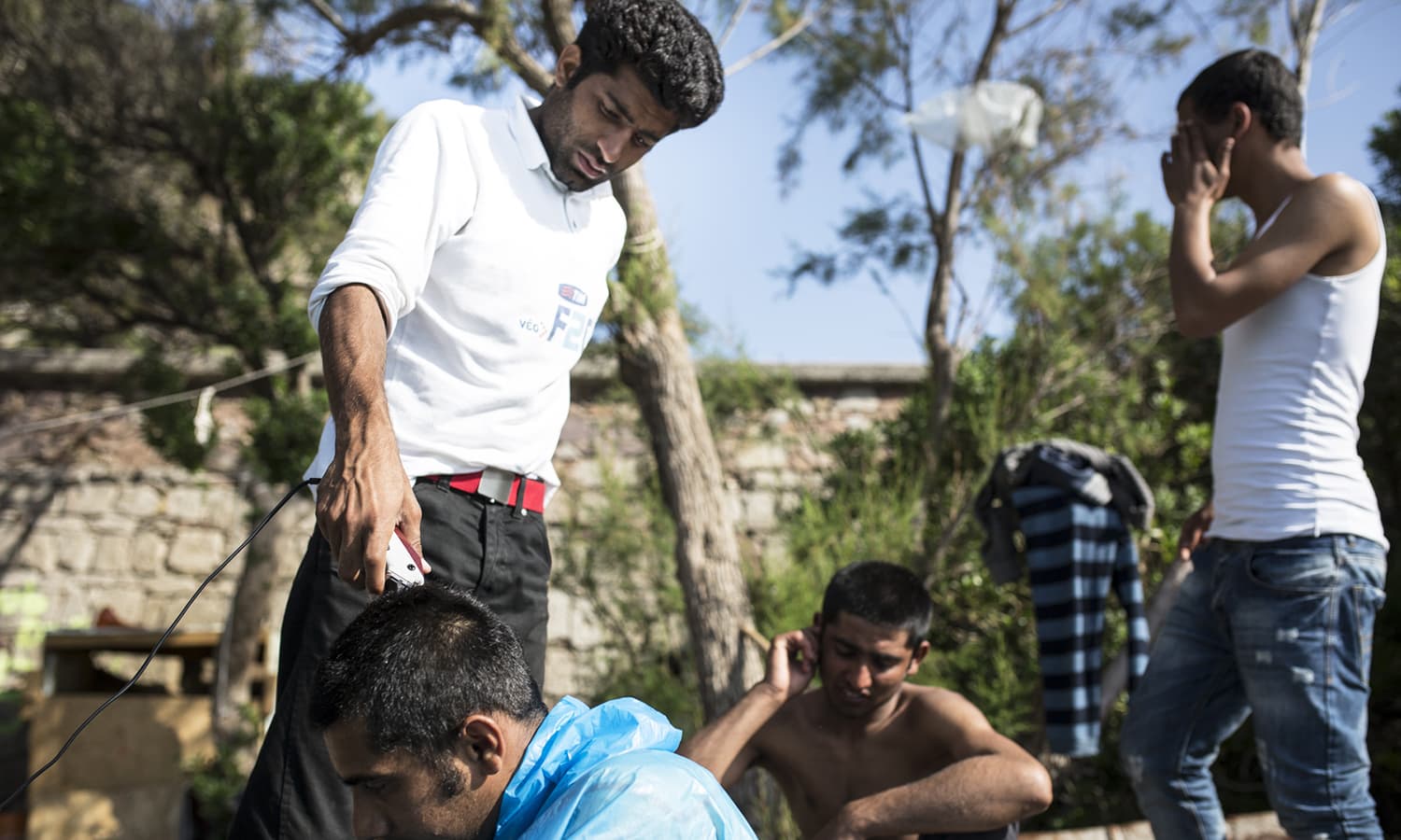 A young Pakistani man named Amer cut Abdil's hair at the No Borders Kitchen, an unlicensed camp run by European anarchists on the shore of Lesbos island in Greece.