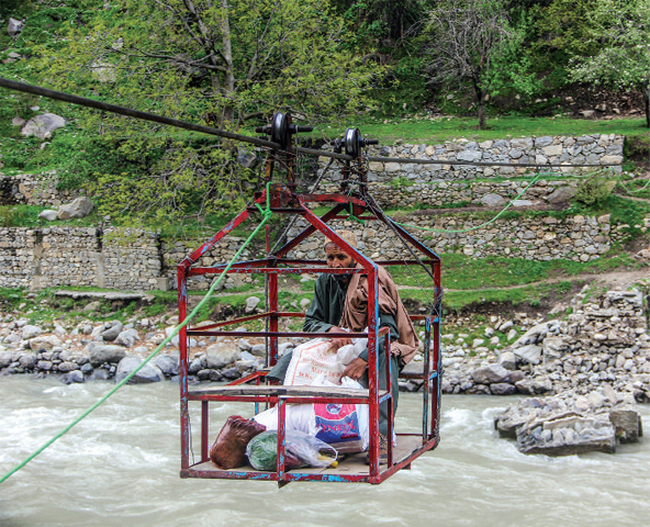 A man crosses Swat River in a chairlift. — Dawn