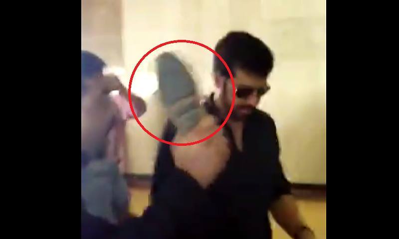 مشتعل افراد کبیر خان کو جوتا دکھا رہے ہیں&mdash;۔ڈان نیوز