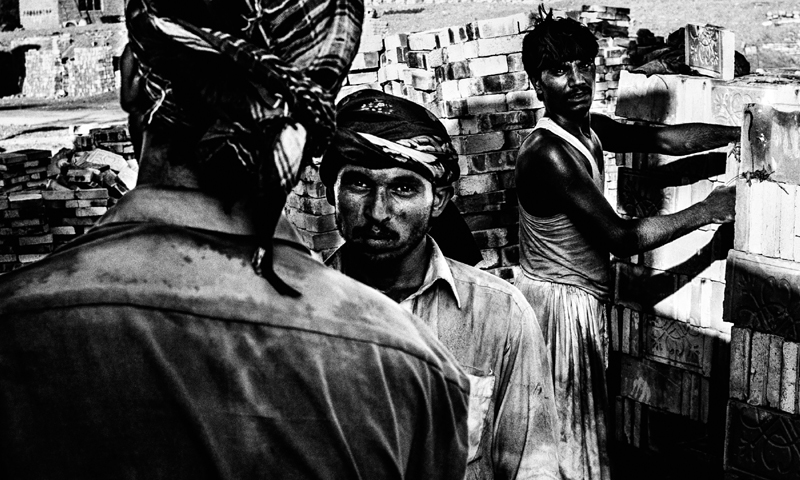 Labourers load trucks with mud bricks at a factory on the outskirts of Hyderabad.