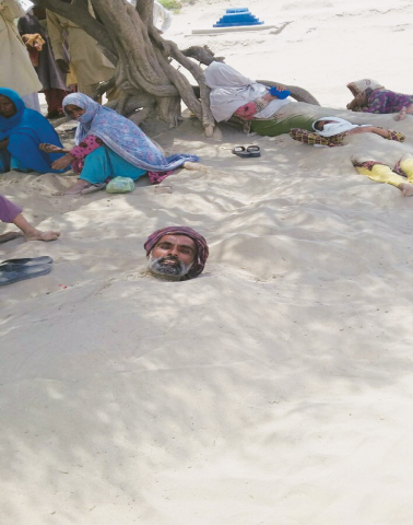 A MAN buried up to the neck in sand at the Pir Muhib Jahanian shrine in Muzaffargarh.&mdash;Photo by writer