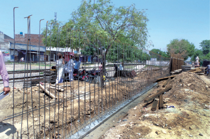 GUJRAT: A concrete wall is being constructed along the track near the railway station. &mdash; Dawn