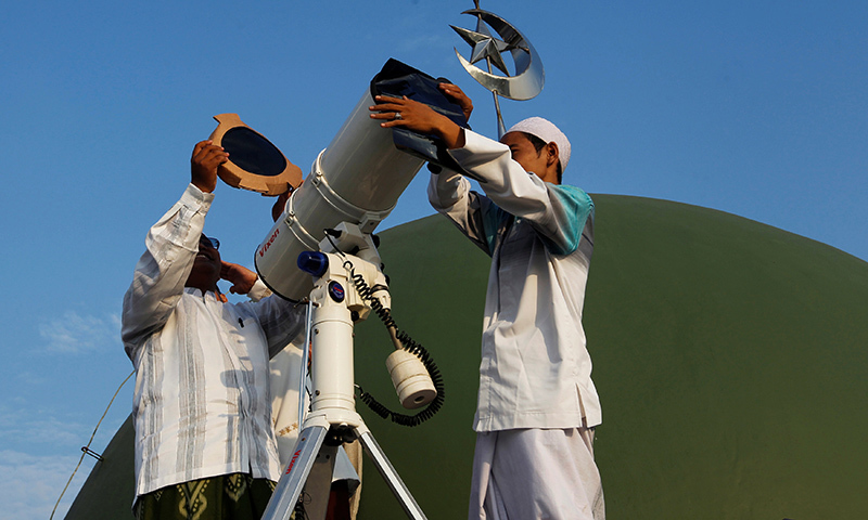 Indonesians use a telescope to observe the moon before the holy month of Ramazan at Al-Musyari'in mosque in Jakarta.─Reuters