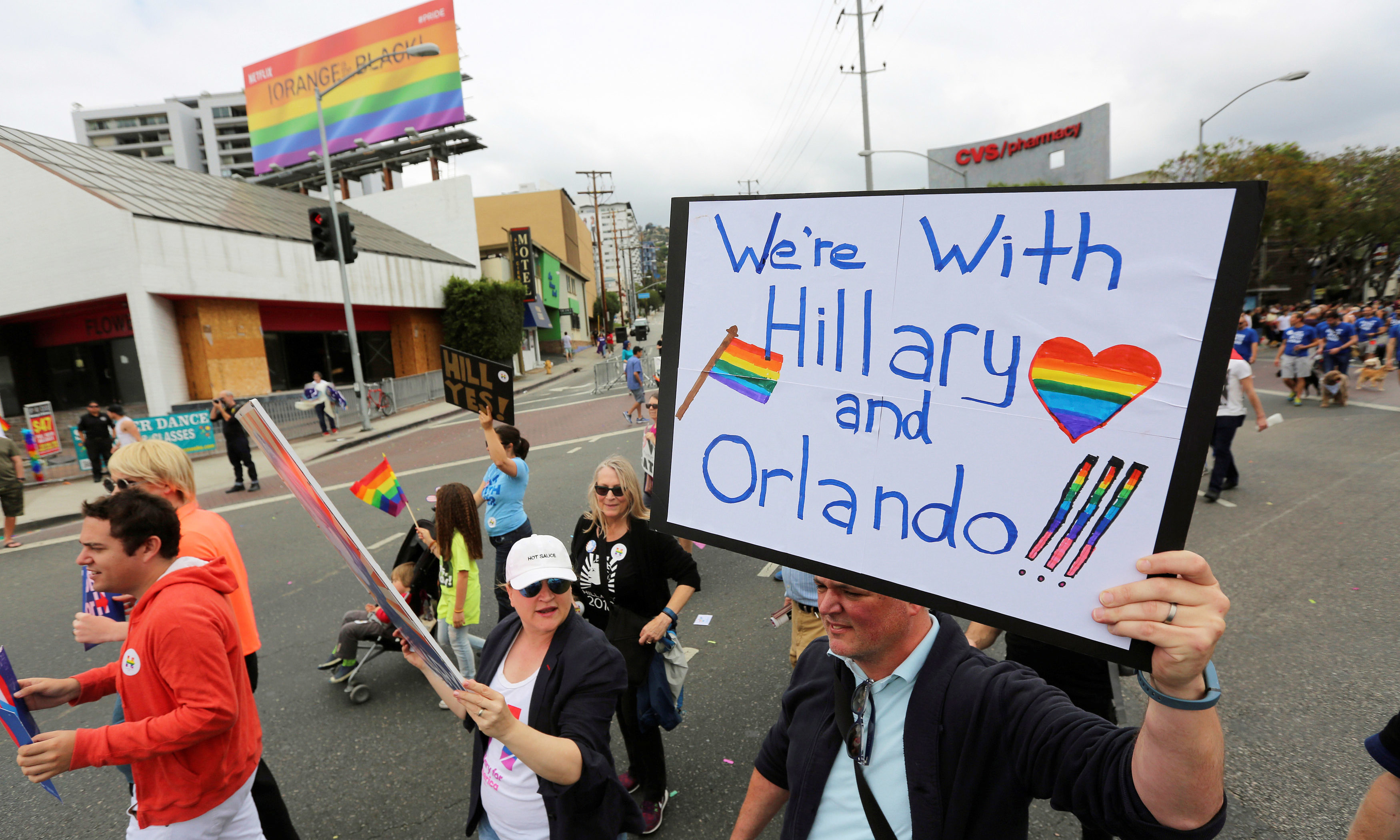 A man carries a sign supporting both the Orlando shooting victims and Democratic presidential candidate Hillary Clinton at the 46th annual Los Angeles Gay Pride Parade in West Hollywood, California. —Reuters