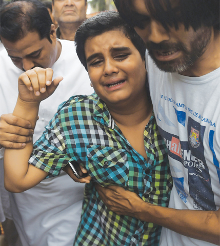 A Relative comforts Mujaddid Sabri, a son of the slain Amjad Sabri, at his residence on Wednesday.—AFP