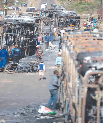 PRETORIA: People from Mamelodi district on Wednesday scavenge for serviceable parts from the remains of vehicles torched during three-day protests.&mdash;AFP