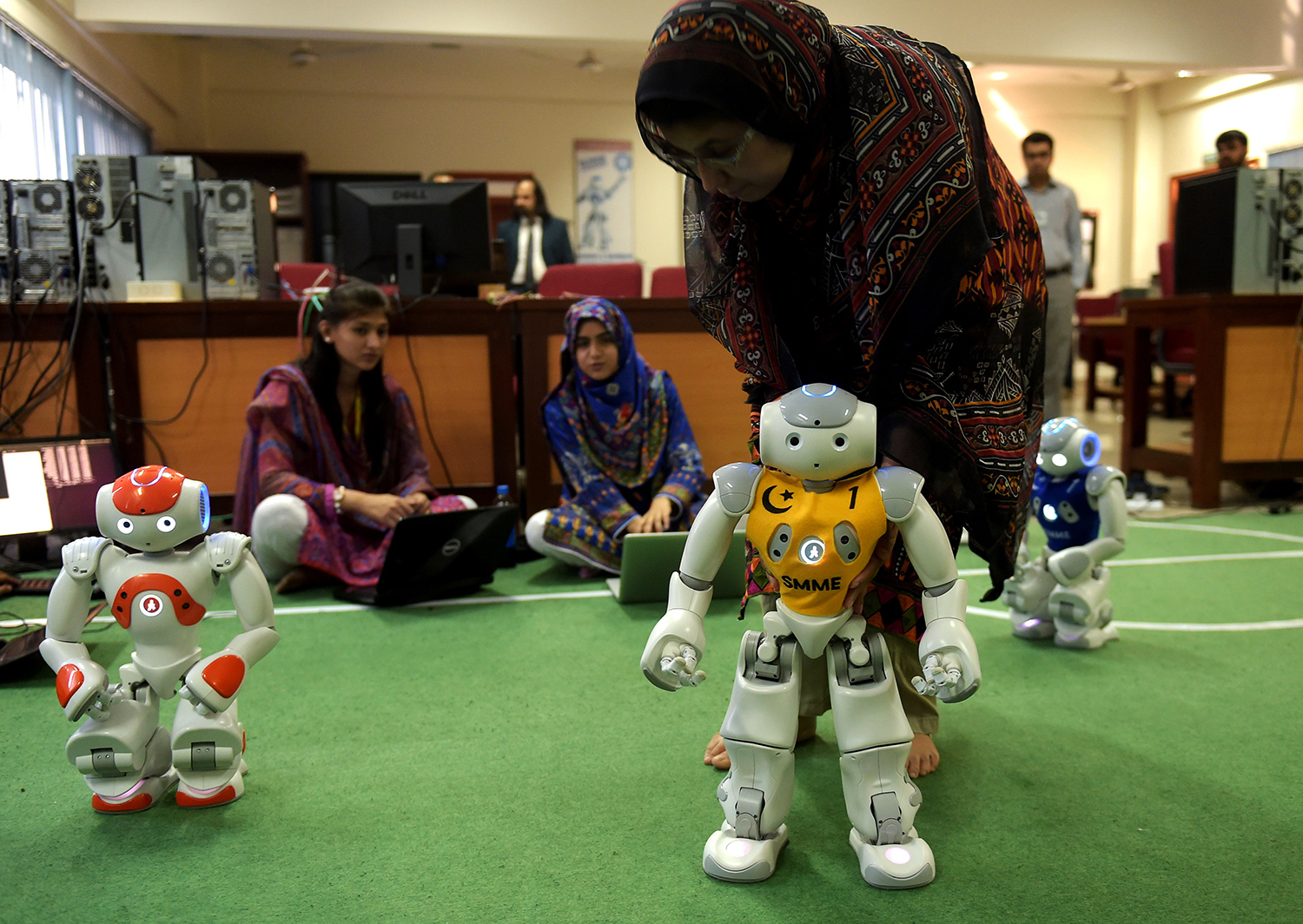 students and team members of Robotics and Intelligence Systems Engineering (RISE) programme their robot football players. — AFP