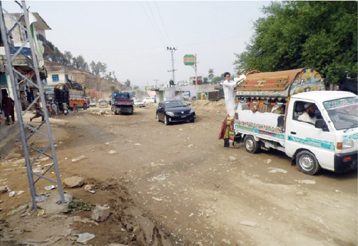 Vehicles pass through the dilapidated Chakdara-Timergara Road. &mdash; Dawn