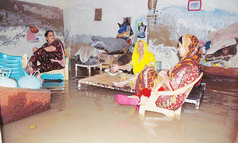 WOMEN of a family sit in their flooding-hit house in the Latifabad area of Hyderabad on Sunday.&mdash;Dawn