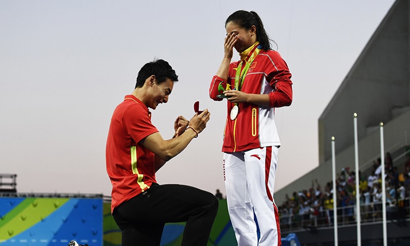 Silver medallist China's He Zi, receives a marriage proposal from Chinese diver Qin Kai during the podium ceremony. -AFP