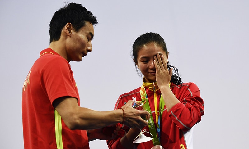 Silver medallist China's He Zi (R), reacts she receives a marriage proposal from Chinese diver Qin Kai during the podium ceremony. -AFP