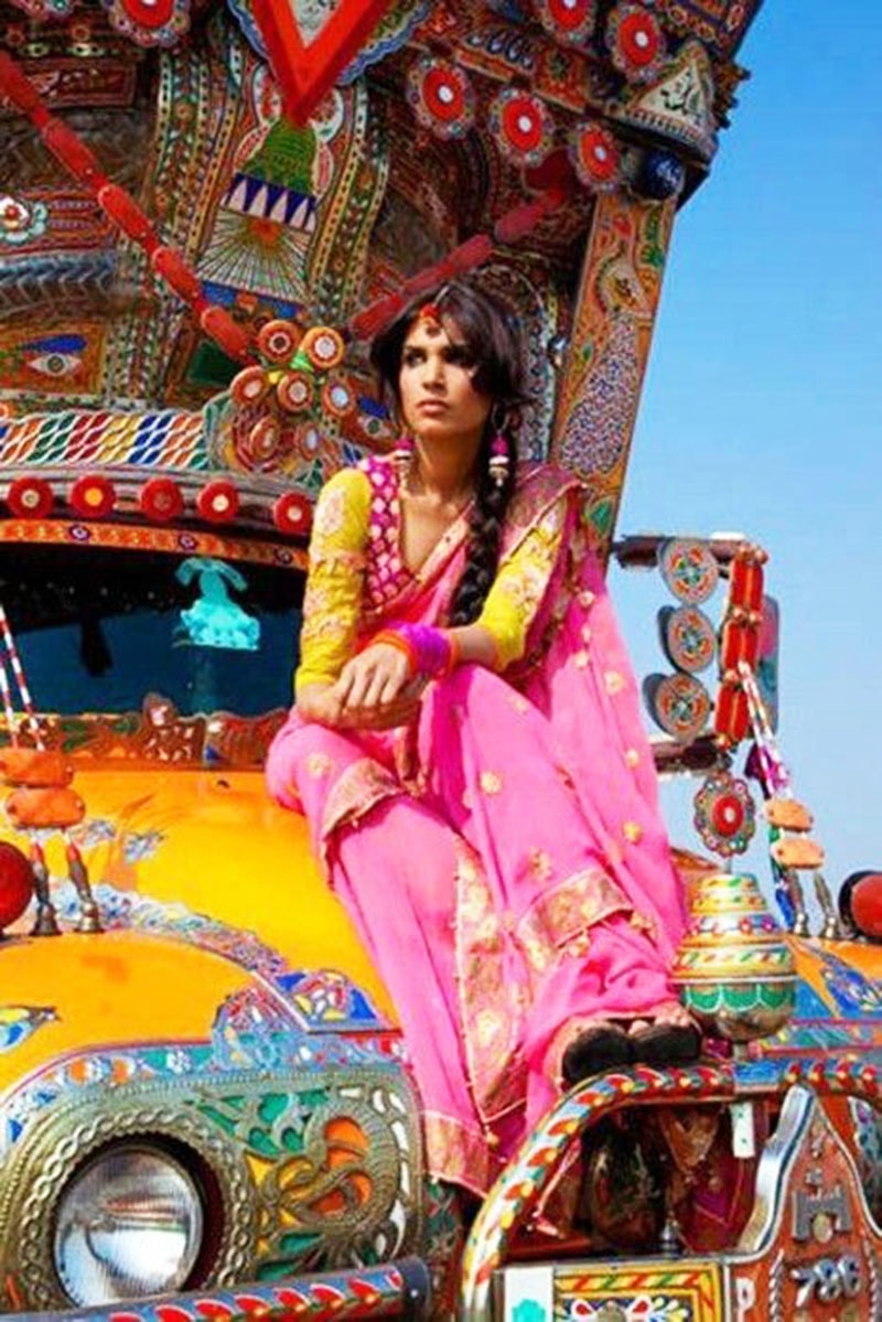 A model dressed in traditional Punjabi dress poses on a truck.