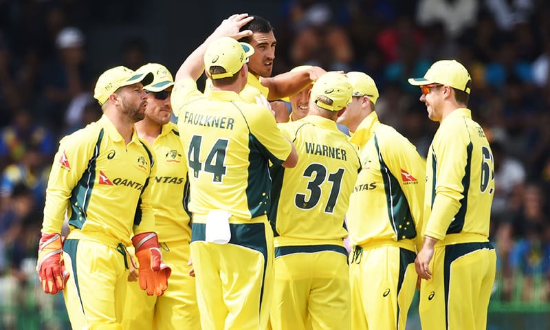Australian cricketer Mitchell Starc (C) celebrates with teammates after taking a wicket. &mdash; AFP