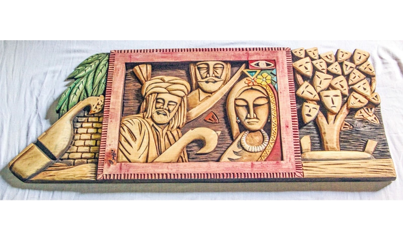 (Above) Nasar Sheen works at his home. (Below) A wooden artefact featuring Pashto folk tale &lsquo;Adam Khan Durkhanai&rsquo;. &mdash; Dawn