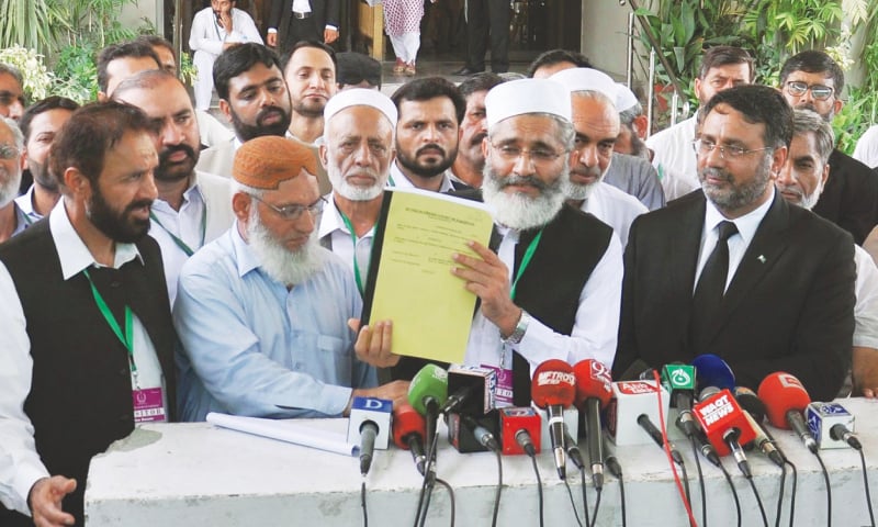 JI chief Sirajul Haq presents a copy of the party's petition to the media — Dawn/File