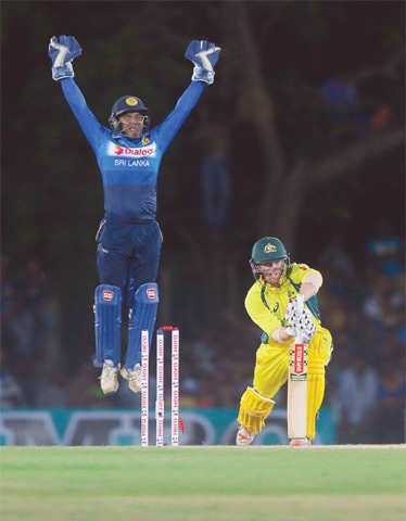 DAMBULLA: Australian batsman George Bailey is cleaned up as Sri Lankan wicket-keeper Kusal Perera celebrates during the third One-day International on Sunday.—AP