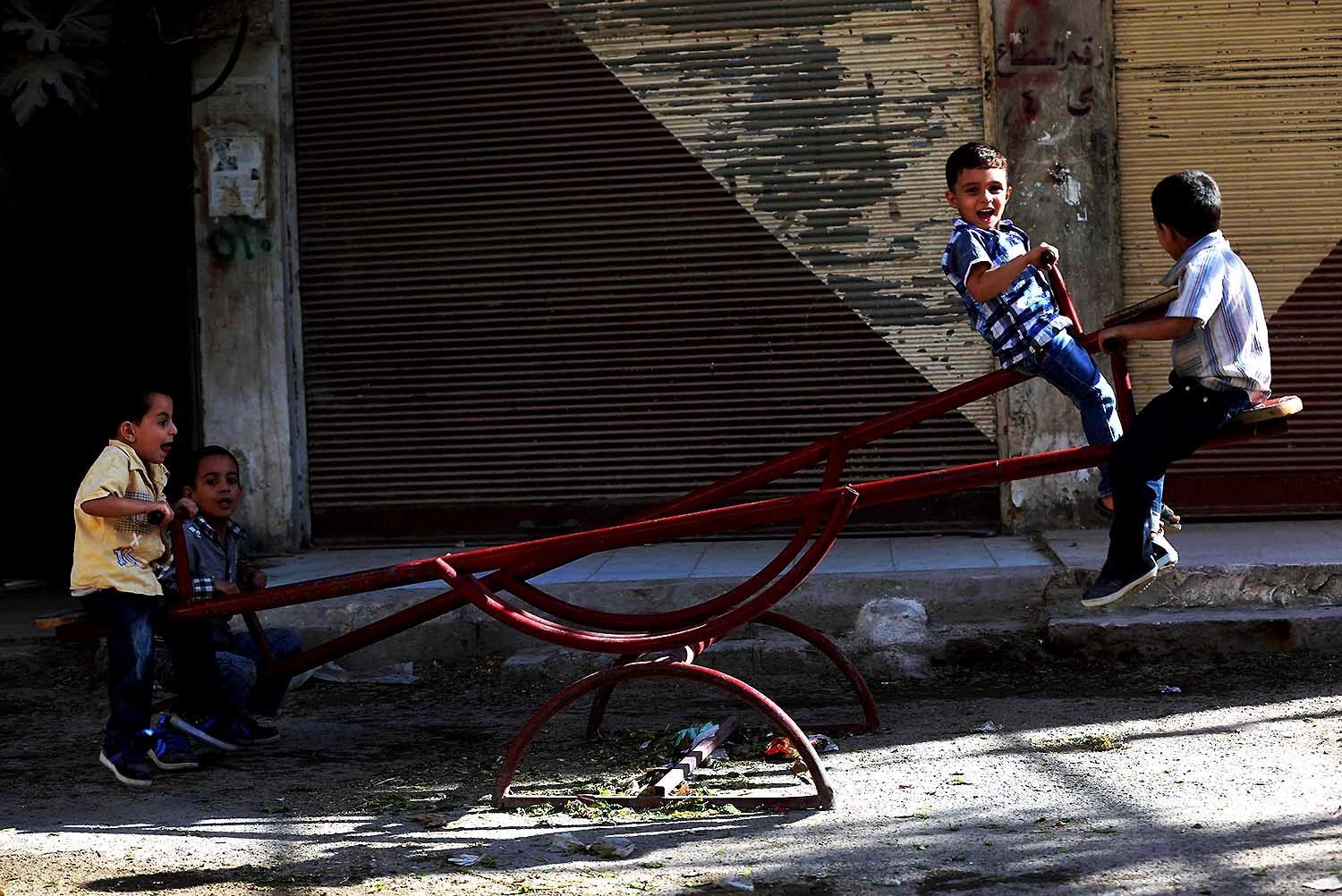 Boys play on a see-saw in Arbin. — AFP