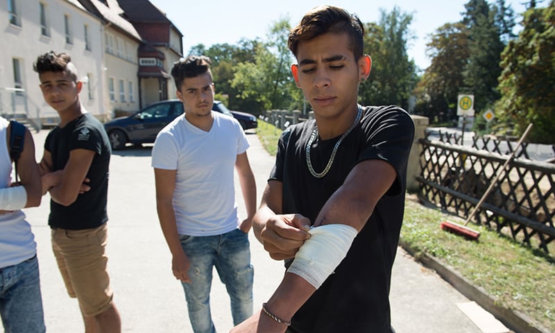 Mehdi, right, from Morocco shows an injury on his arm in Bautzen, which he says he suffered during riots ─ AP