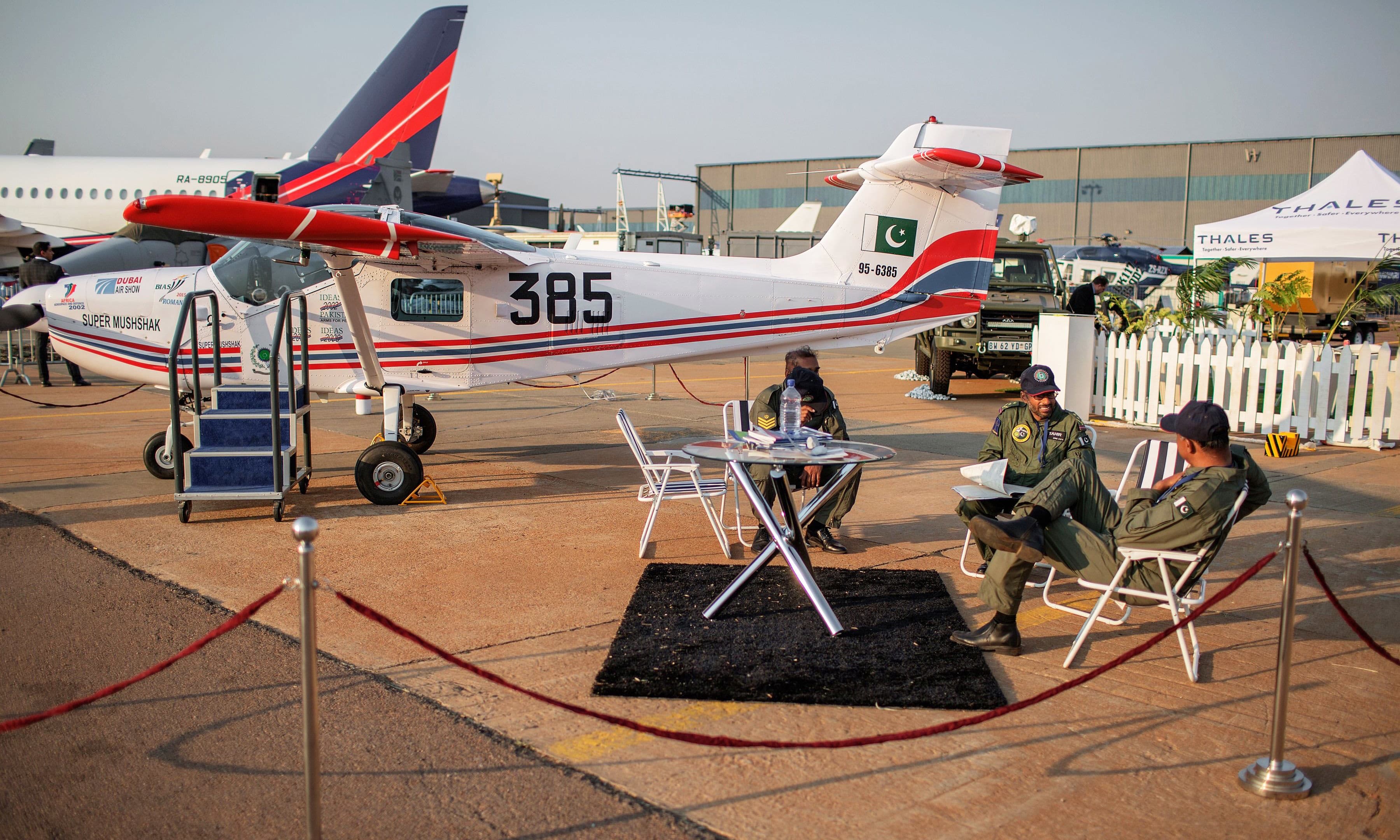 Pakistani Air Force officials sit on the runaway of a military plane during the Africa Aerospace and Defence 2016 fair at the South African air force Waterkloof base. —AFP