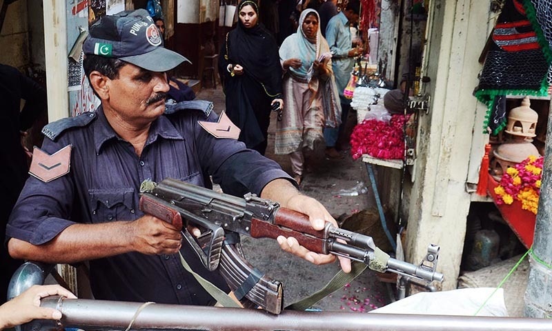 Policeman standing alert to avert any untoward incident at Bibi Pak Daman Bazaar in Lahore. —Online