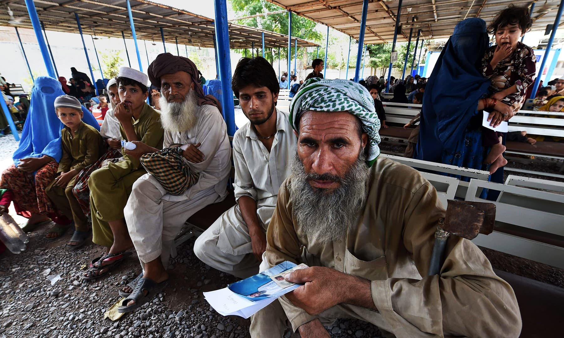 Afghan refugees wait to register at the UNHCR repatriation centre on the outskirts of Peshawar. — AFP