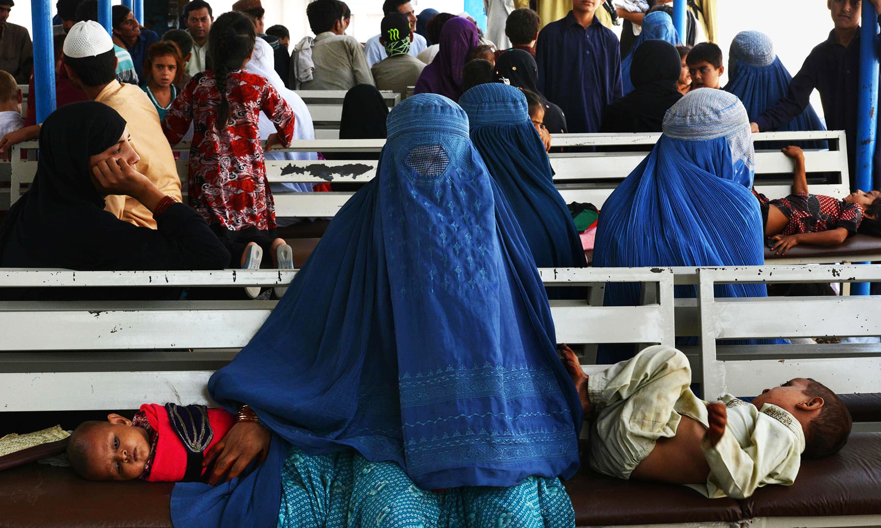 Afghan refugees wait to register at the UNHCR repatriation centre on the outskirts of Peshawar. — AFP