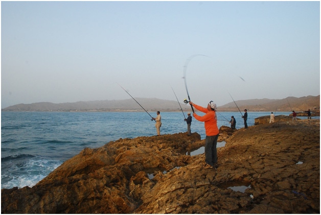 Men fishing at the Mubarak Village Beach.