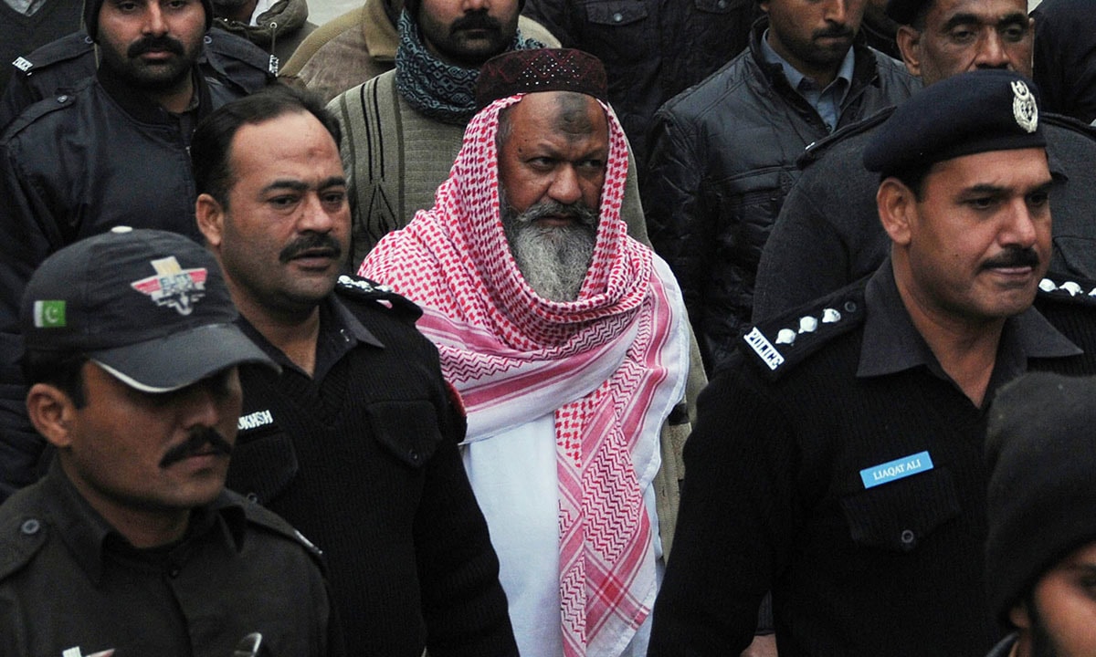 Policemen escort Malik Ishaq, the head of the banned militant outfit Lashkar-e-Jhangvi, in December 2014 | AFP