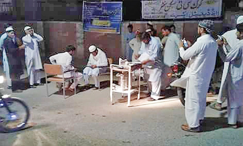 Doctors examine patients under solar-powered streetlights outside Women and Children Hospital, Karak. &mdash; Dawn