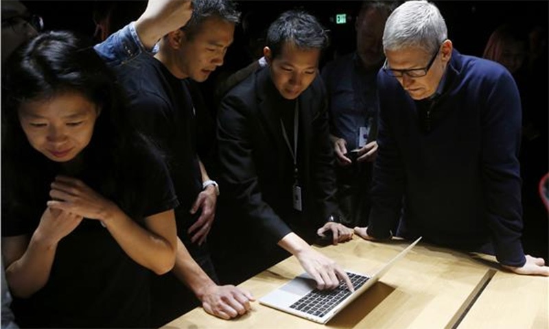 Apple CEO Tim Cook views the new MacBook Pro in the demo room. ─Reuters