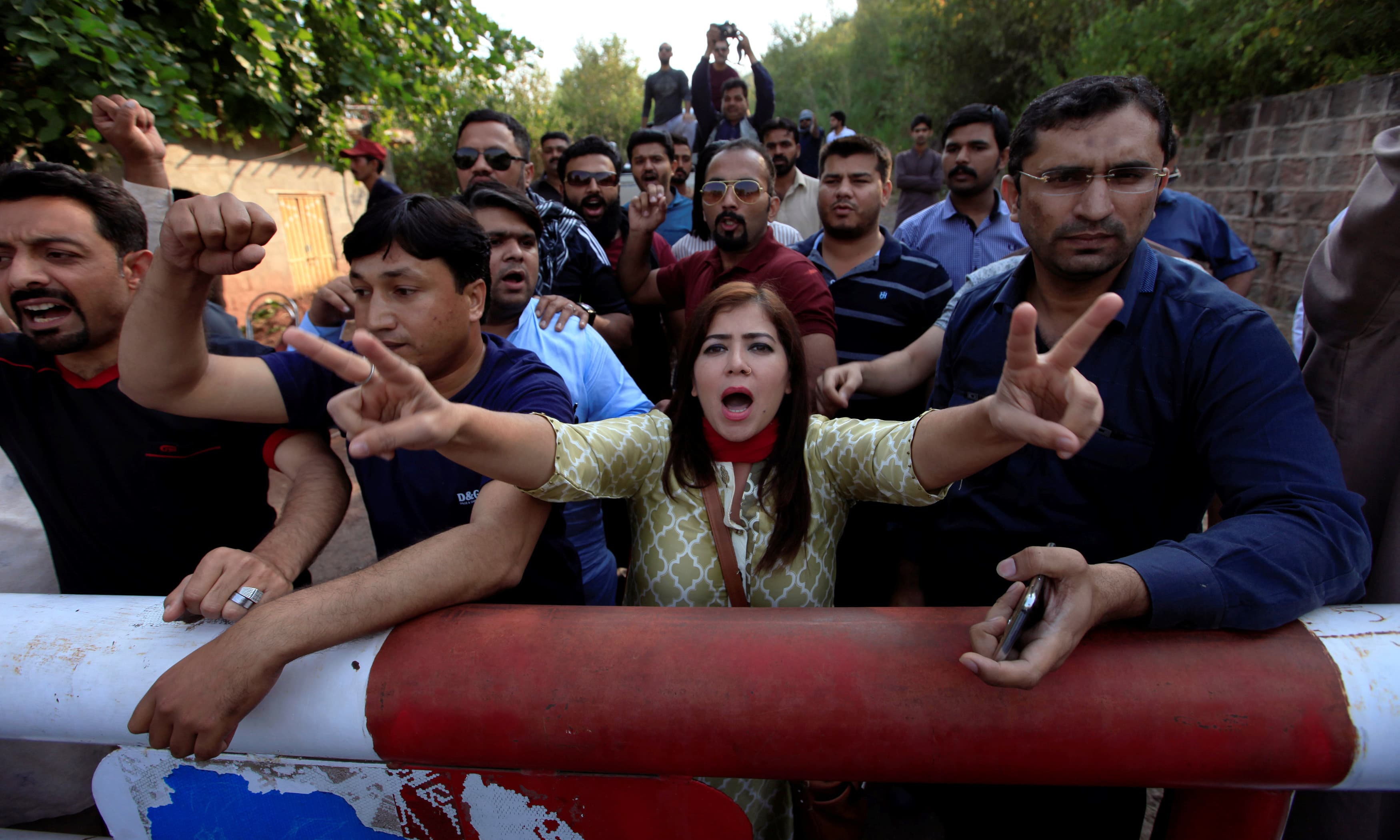 Supporters of Pakistan Tehreek-i-Insaf chant anti-government slogans outside Imran Khan's residence in Islamabad. -Reuters