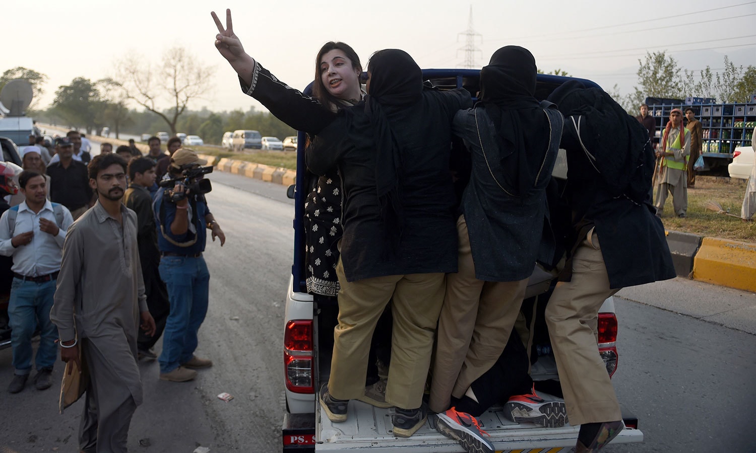 خاتون پولیس اہلکار پی ٹی آئی کارکن کو گرفتار کرکے لے جاتے ہوئے &mdash; فوٹو : اے ایف پی