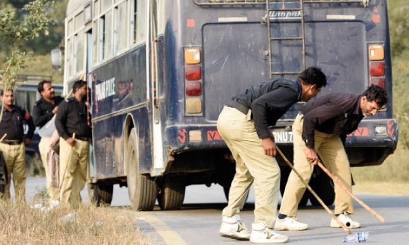 دھرنا ملتوی ہونے کے بعد پولیس اہلکارپانی کی خالی بوتل اور لاٹھی سے کھیلتے ہوئے &mdash; فوٹو: تنویر شہزاد
