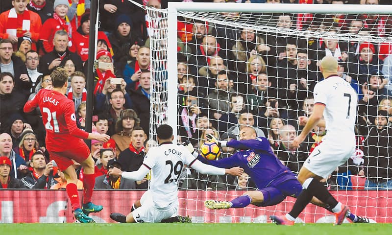 LIVERPOOL: Watford goalkeeper Heurelho Gomes makes a save from Liverpool’s Lucas Leiva (L) during their Premier League match at Anfield on Sunday.—AFP