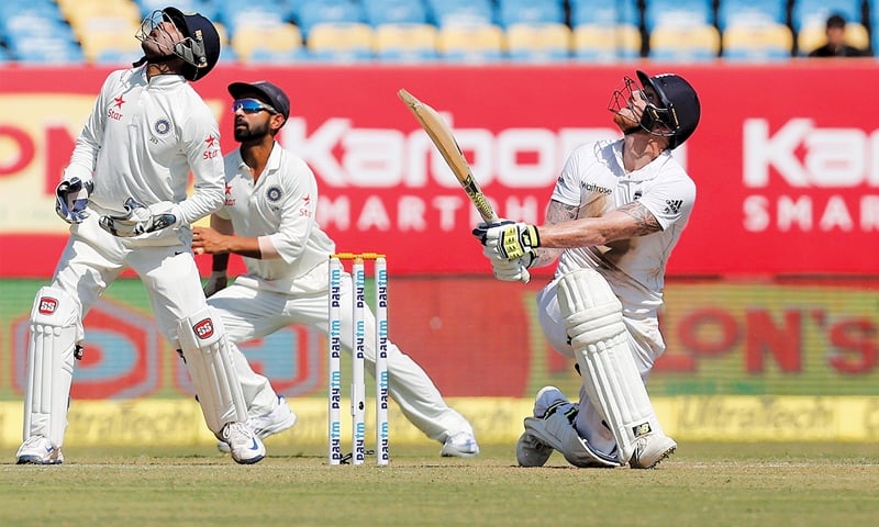 RAJKOT: England&rsquo;s Ben Stokes plays a lofty shot as India&rsquo;s wicket-keeper Wriddhiman Saha and Ajinkya Rahane watch during the first Test at the SCA Stadium on Thursday.&mdash;Reuters