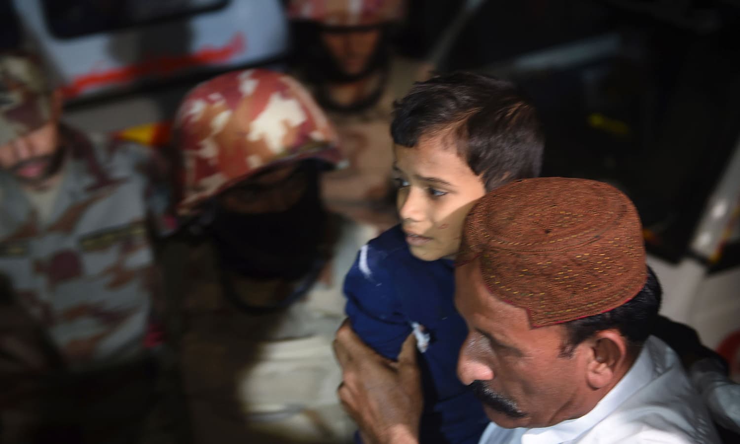 A man carries a boy injured after a bomb blast at a hospital in the Hub district. ─ AFP