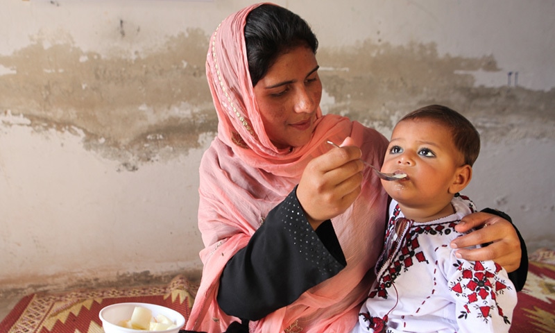 An 18-month old child is fed by his mother in Muzaffargarh.— UNICEF/Pakistan/Giacomo Pirozzi