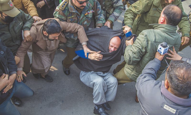 Policemen detain IHK lawmaker Engineer Abdul Rashid Sheikh after he was stopped from offering prayers at Srinagar's main mosque on Friday.&mdash; AP